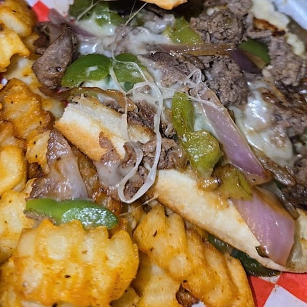 Close-up of Cesar's Snack Shack's Philly Cheesesteak fries with steak, peppers, onions, and melted cheese.